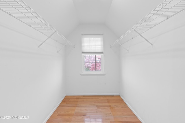 walk in closet with lofted ceiling and light wood finished floors