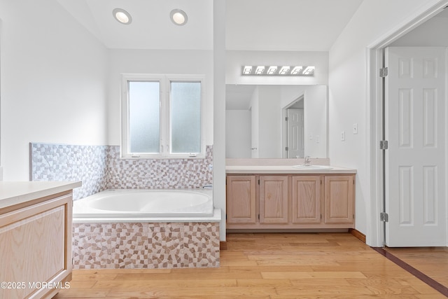 bathroom featuring vanity, a garden tub, and wood finished floors