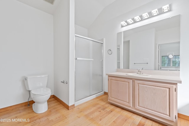 bathroom with vanity, wood finished floors, toilet, and a shower stall