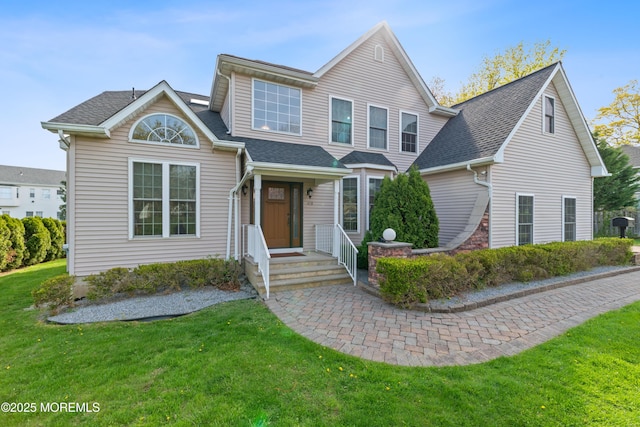 view of front of property with a shingled roof and a front yard