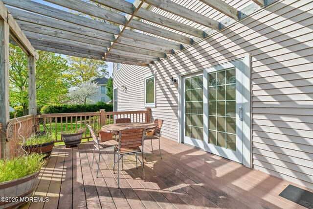 wooden deck with a pergola and outdoor dining area