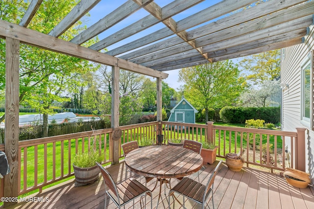 deck with fence, a storage unit, an outbuilding, and a yard