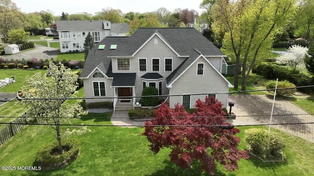 view of front of home featuring a shingled roof and fence
