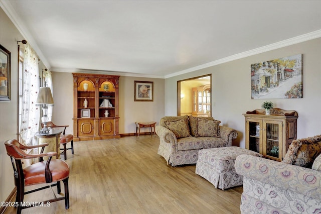 living room featuring plenty of natural light, crown molding, light wood-style flooring, and baseboards
