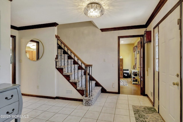 foyer featuring light tile patterned flooring, stairs, crown molding, and baseboards