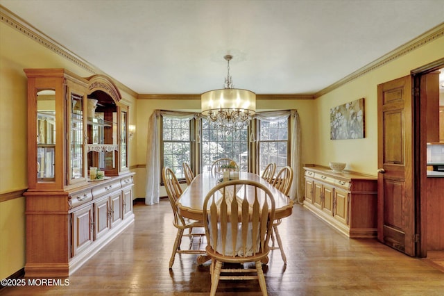dining space featuring a chandelier, wood finished floors, and ornamental molding