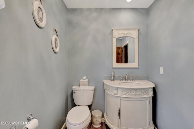 half bathroom featuring toilet and vanity