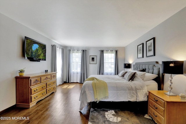 bedroom featuring dark wood-style flooring and baseboards