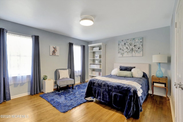 bedroom featuring baseboards and wood finished floors