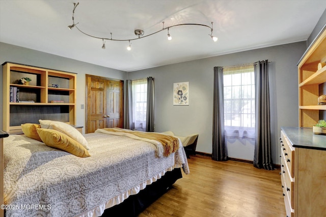 bedroom featuring wood finished floors and baseboards
