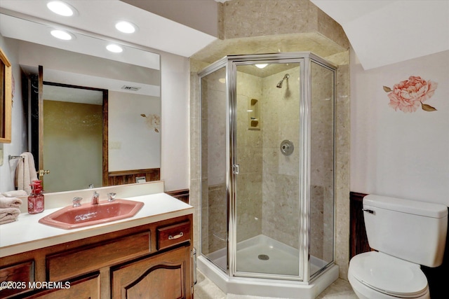 full bath with a stall shower, toilet, recessed lighting, and vanity