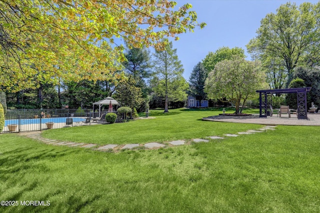 view of yard featuring a gazebo, a community pool, a pergola, a patio area, and an outdoor structure