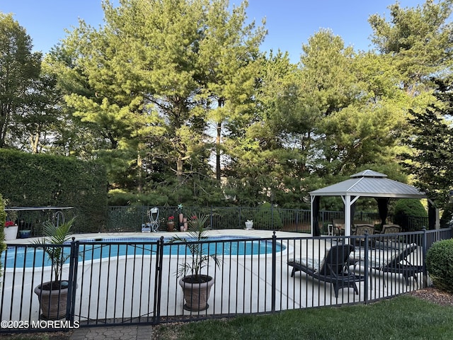 view of swimming pool with a gazebo, fence, a patio, and view of scattered trees
