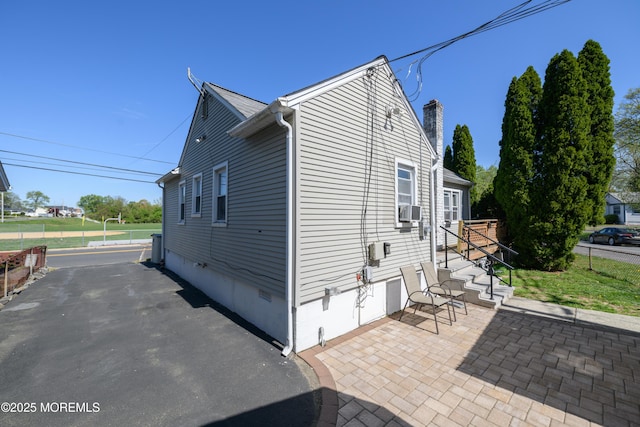 view of home's exterior featuring fence, crawl space, a chimney, cooling unit, and a patio area