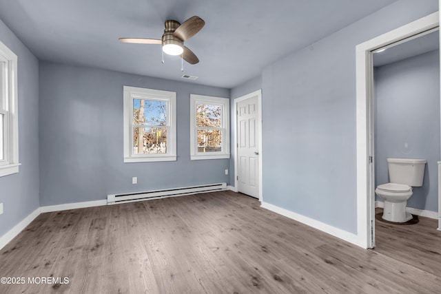 108 Manchester Ave, Forked River, NJ 08731 - unfurnished bedroom with connected bathroom, visible vents, baseboards, wood finished floors, and a baseboard heating unit