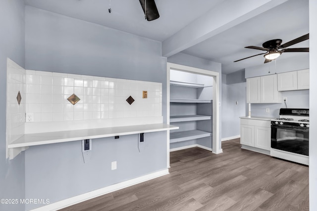 108 Manchester Ave, Forked River, NJ 08731 - kitchen with ceiling fan, gas range, a kitchen bar, white cabinetry, and dark wood finished floors