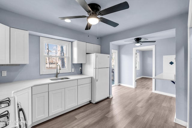 108 Manchester Ave, Forked River, NJ 08731 - kitchen featuring ceiling fan, a sink, white appliances, light wood-style flooring, and white cabinetry