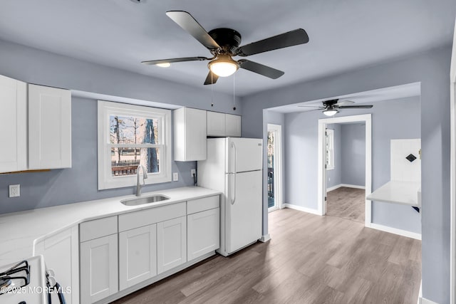 108 Manchester Ave, Forked River, NJ 08731 - kitchen with a ceiling fan, white appliances, white cabinetry, a sink, and light wood finished floors