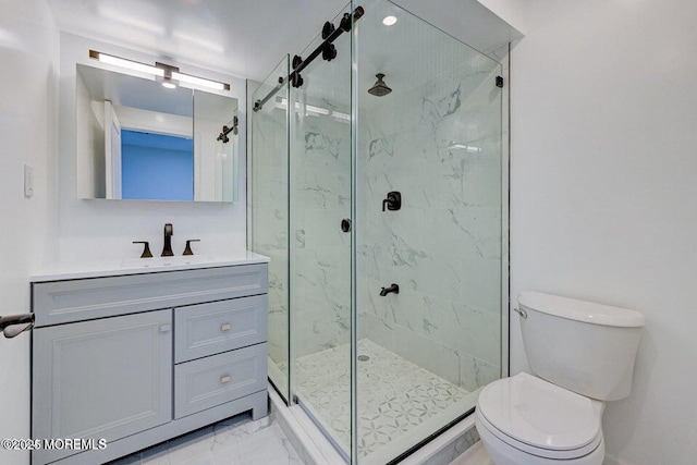 full bath featuring vanity, marble finish floor, a marble finish shower, and toilet