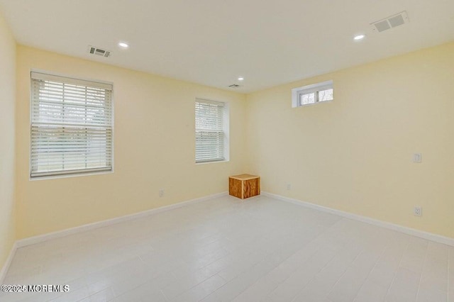 spare room featuring baseboards, recessed lighting, and visible vents