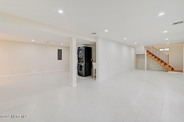 finished below grade area featuring recessed lighting, stairway, visible vents, and stacked washer and clothes dryer