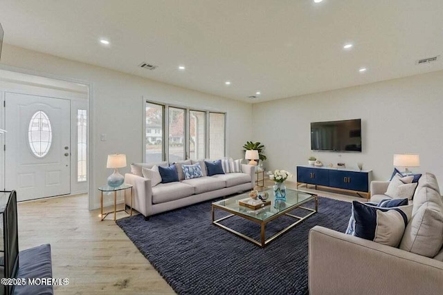 living room with recessed lighting, visible vents, and light wood-style flooring