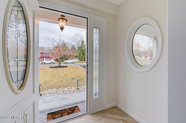 entryway featuring baseboards and light wood finished floors