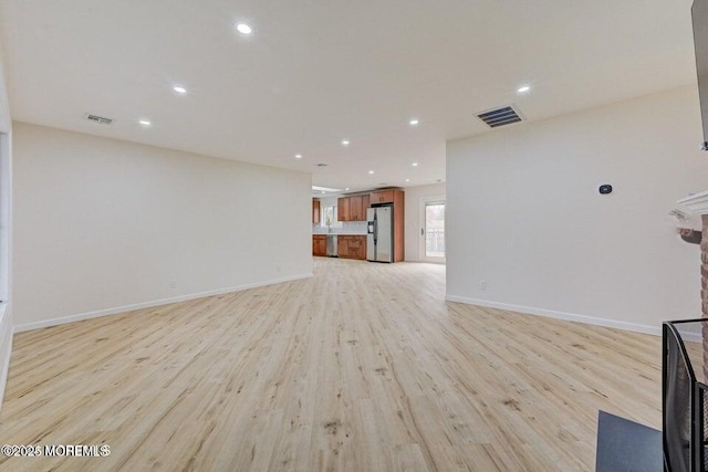unfurnished living room with recessed lighting, visible vents, and light wood finished floors