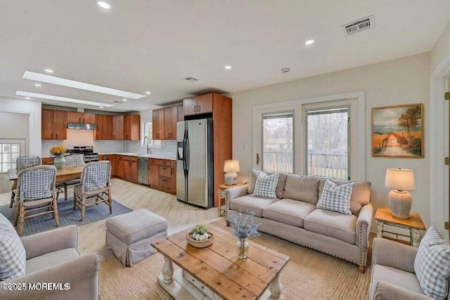 living room with recessed lighting, light wood-type flooring, and visible vents