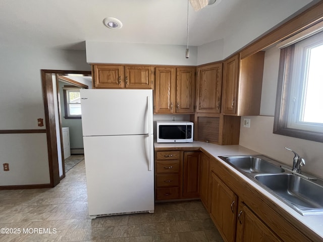 2015 5th Ave, Spring Lake, NJ 07762 - kitchen featuring freestanding refrigerator, a sink, brown cabinets, and a wealth of natural light