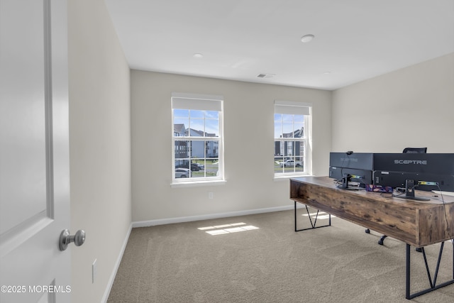 carpeted office space with baseboards and visible vents