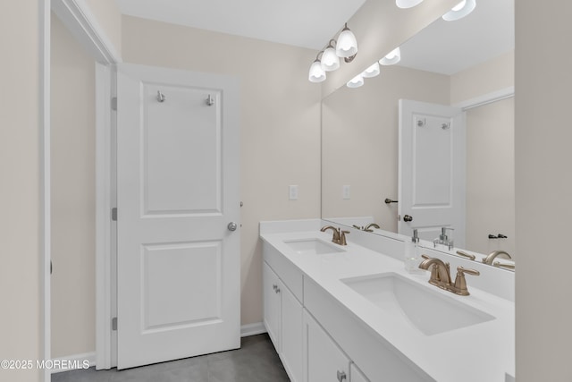 bathroom featuring a sink, baseboards, tile patterned flooring, and double vanity