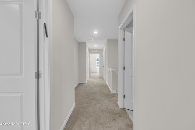 hallway featuring recessed lighting, baseboards, visible vents, and light carpet