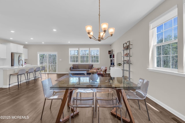 dining area featuring visible vents, wood finished floors, baseboards, recessed lighting, and a chandelier