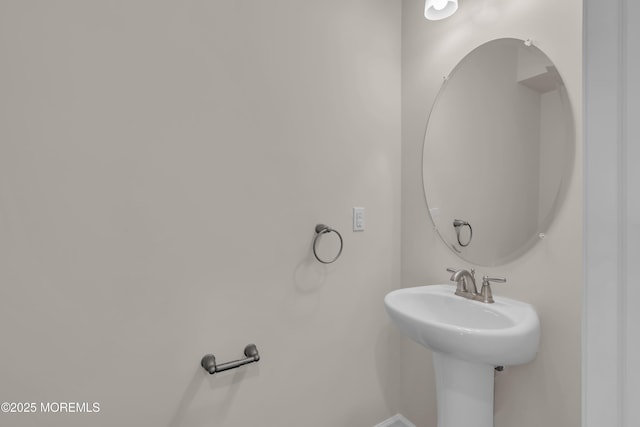 bathroom featuring baseboards and a sink