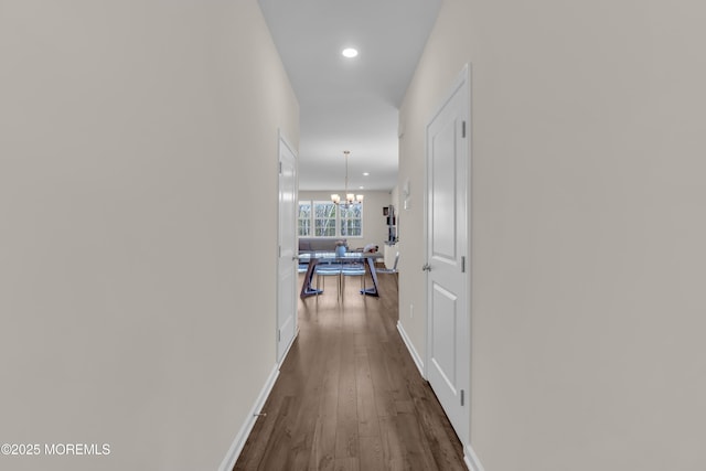 hall with baseboards, a notable chandelier, recessed lighting, and dark wood-type flooring