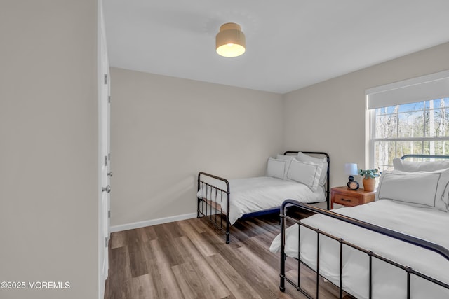 bedroom with baseboards and wood finished floors