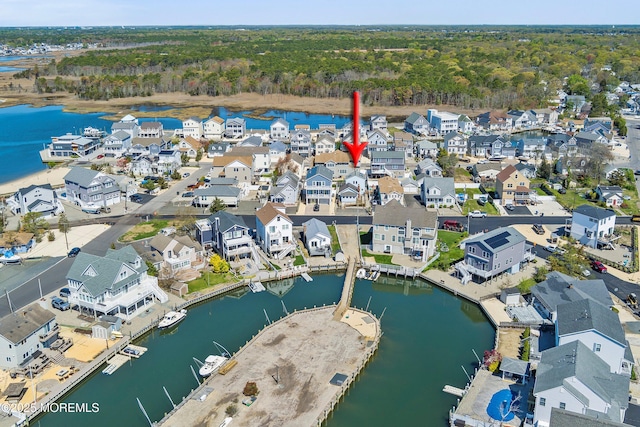 drone / aerial view with a residential view, a water view, and a forest view