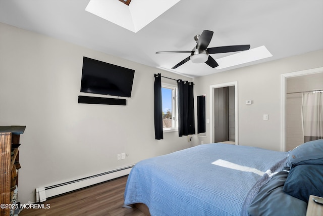 bedroom with a skylight, ceiling fan, a baseboard heating unit, and wood finished floors