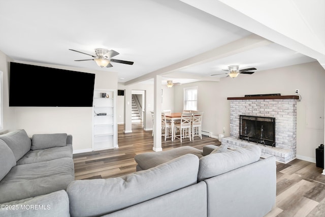 living room with baseboards, baseboard heating, ceiling fan, and wood finished floors