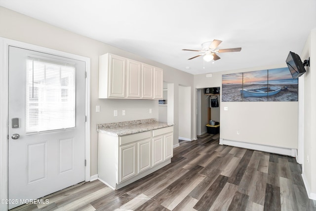 kitchen featuring light countertops, ceiling fan, a baseboard heating unit, and wood finished floors