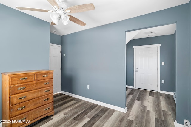 bedroom featuring baseboards, a baseboard heating unit, and dark wood finished floors