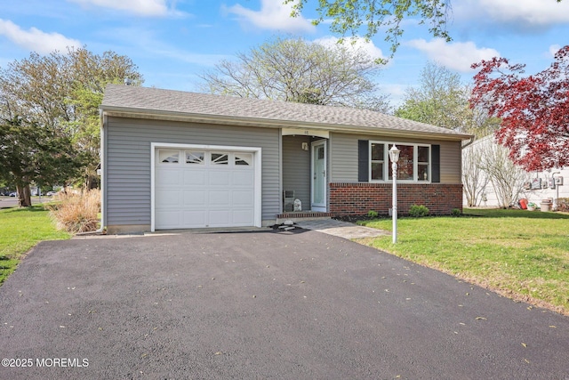 ranch-style house with an attached garage, aphalt driveway, brick siding, and a front yard