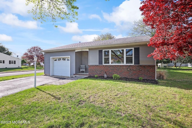 single story home featuring brick siding, an attached garage, a front yard, and aphalt driveway