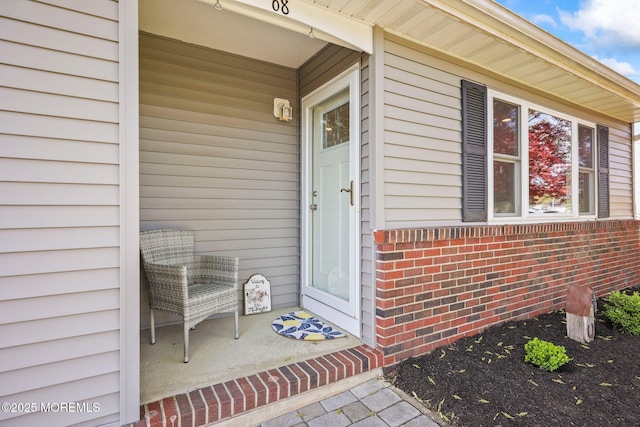 doorway to property featuring brick siding