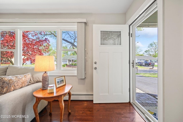 entrance foyer with plenty of natural light, dark wood-type flooring, and a baseboard heating unit