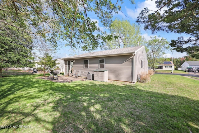 back of property with a lawn, a patio, and central AC