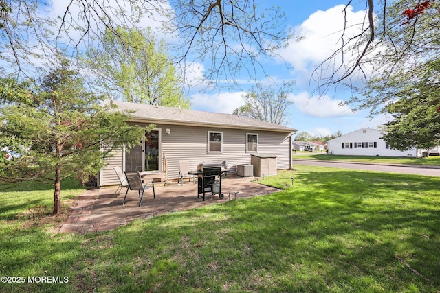 rear view of house featuring a lawn and a patio area