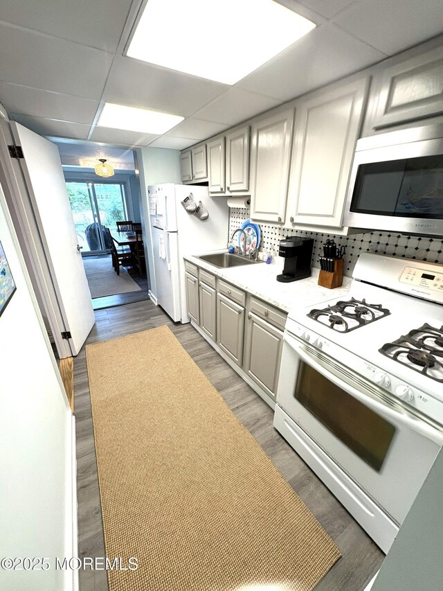 25 O St, Seaside Park, NJ 08752 - kitchen with white range with gas stovetop, stainless steel microwave, light countertops, light wood-type flooring, and a paneled ceiling