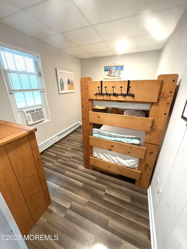 25 O St, Seaside Park, NJ 08752 - bedroom featuring a baseboard heating unit, cooling unit, dark wood-style flooring, a paneled ceiling, and wood walls